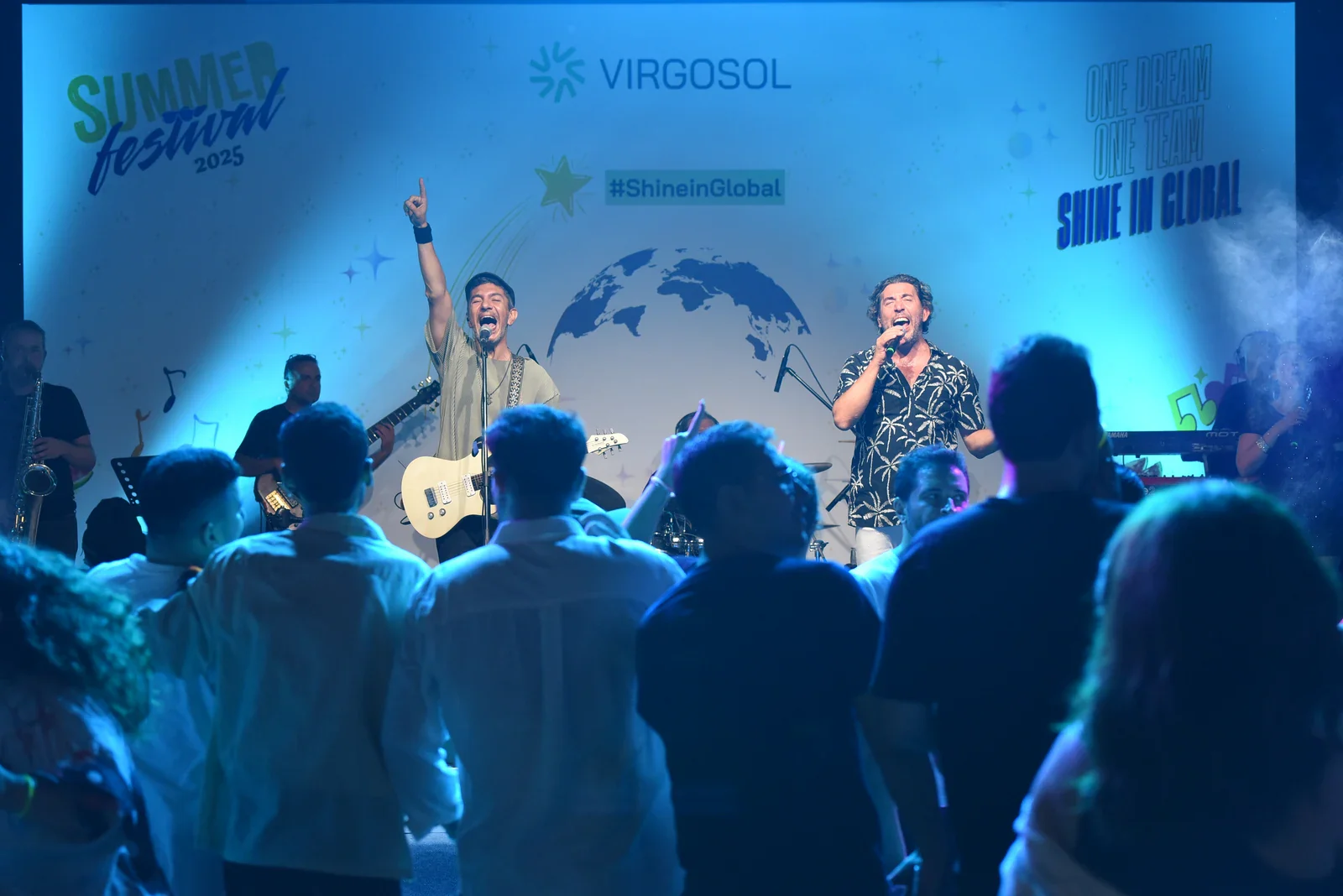 The band on stage at the Virgosol Summer Festival with the team in front